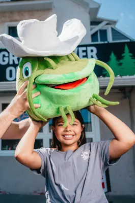 little girl with a mudcat stuffed animal on her head