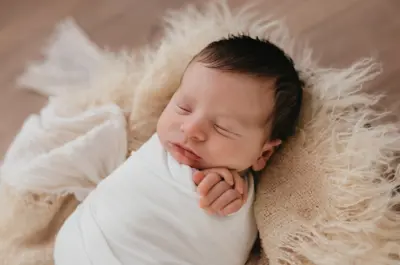 A photo portrait of a swaddled newborn baby 