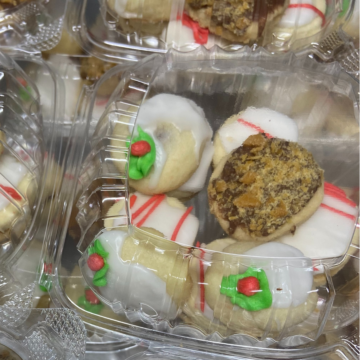 festively decorated cookies in plastic containers on display