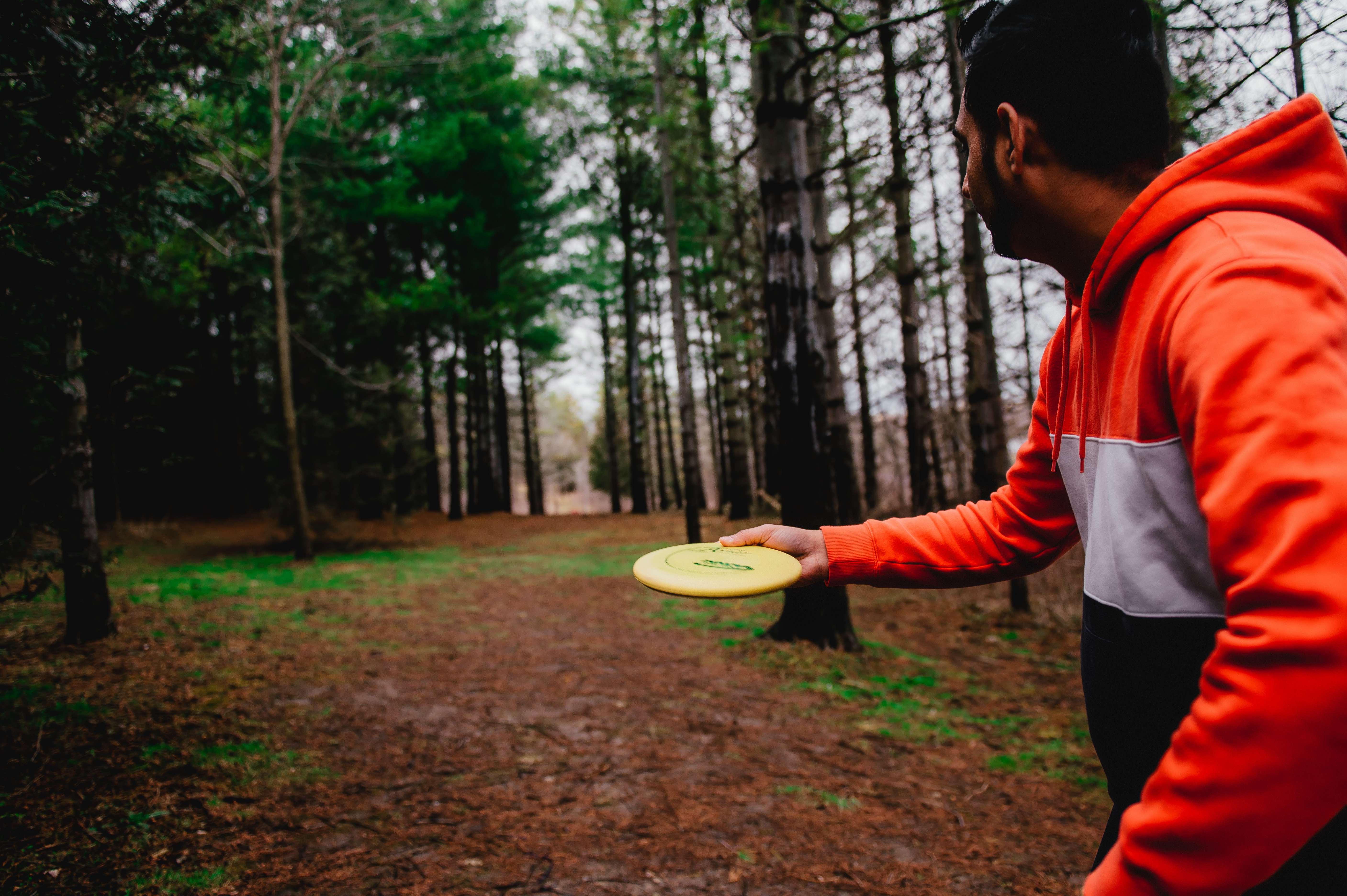 A man holds a yellow disc ready to throw
