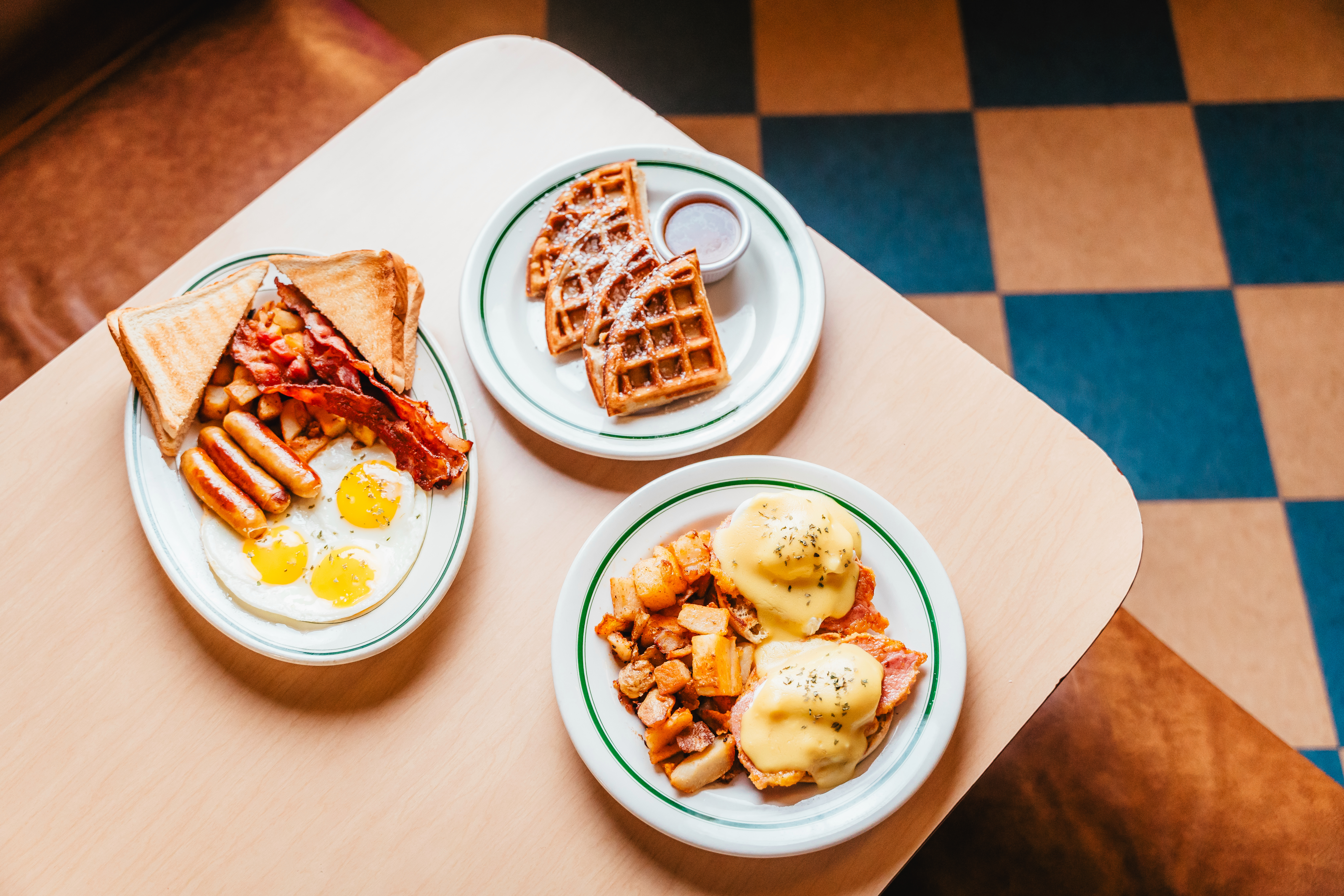 A diner table filled with plates of breakfast foods