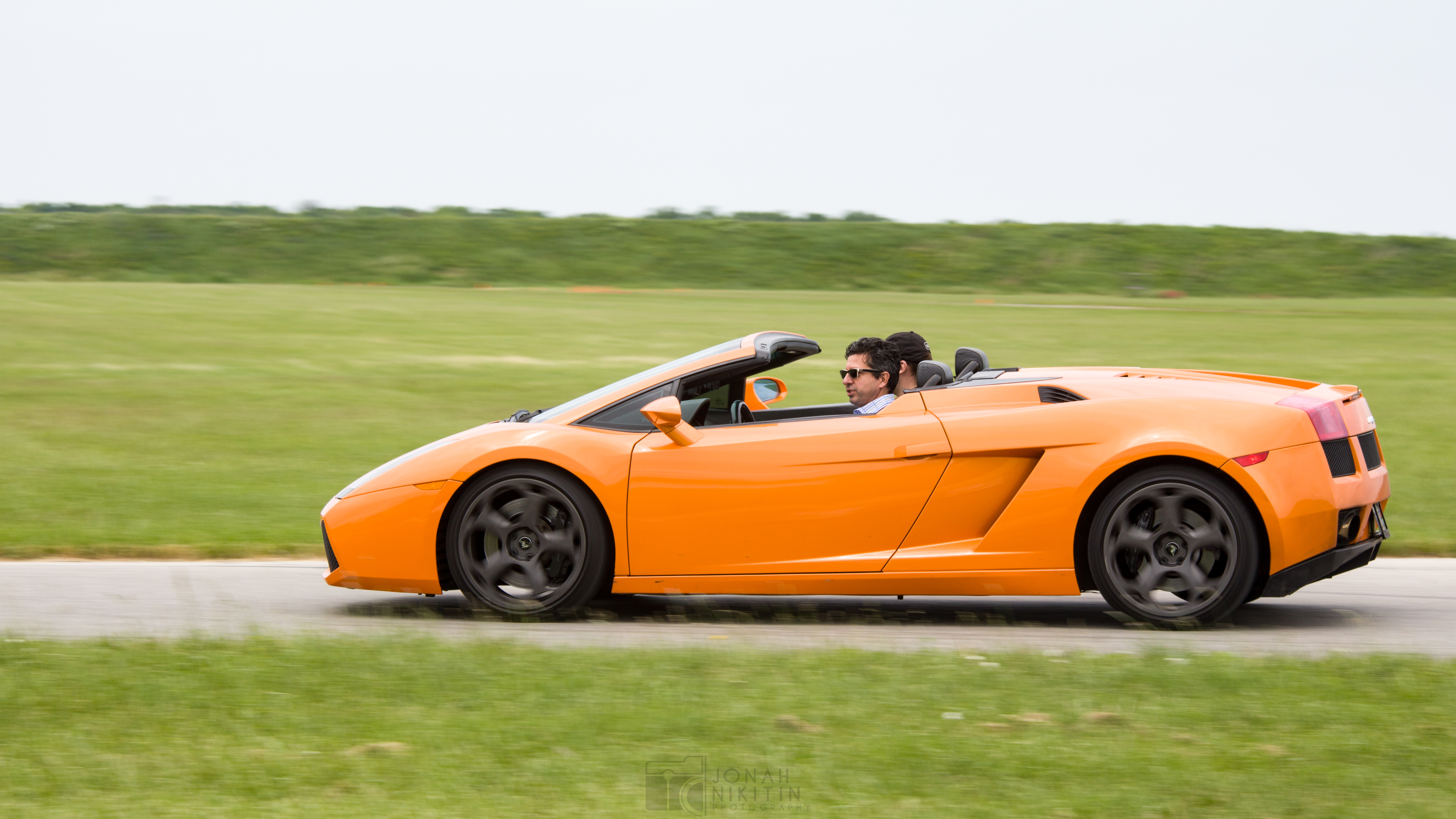 An orange sports car races around a closed loop track