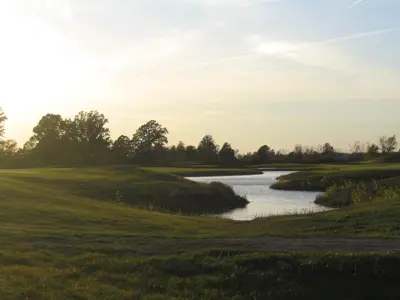 golf course near a pond during sunset