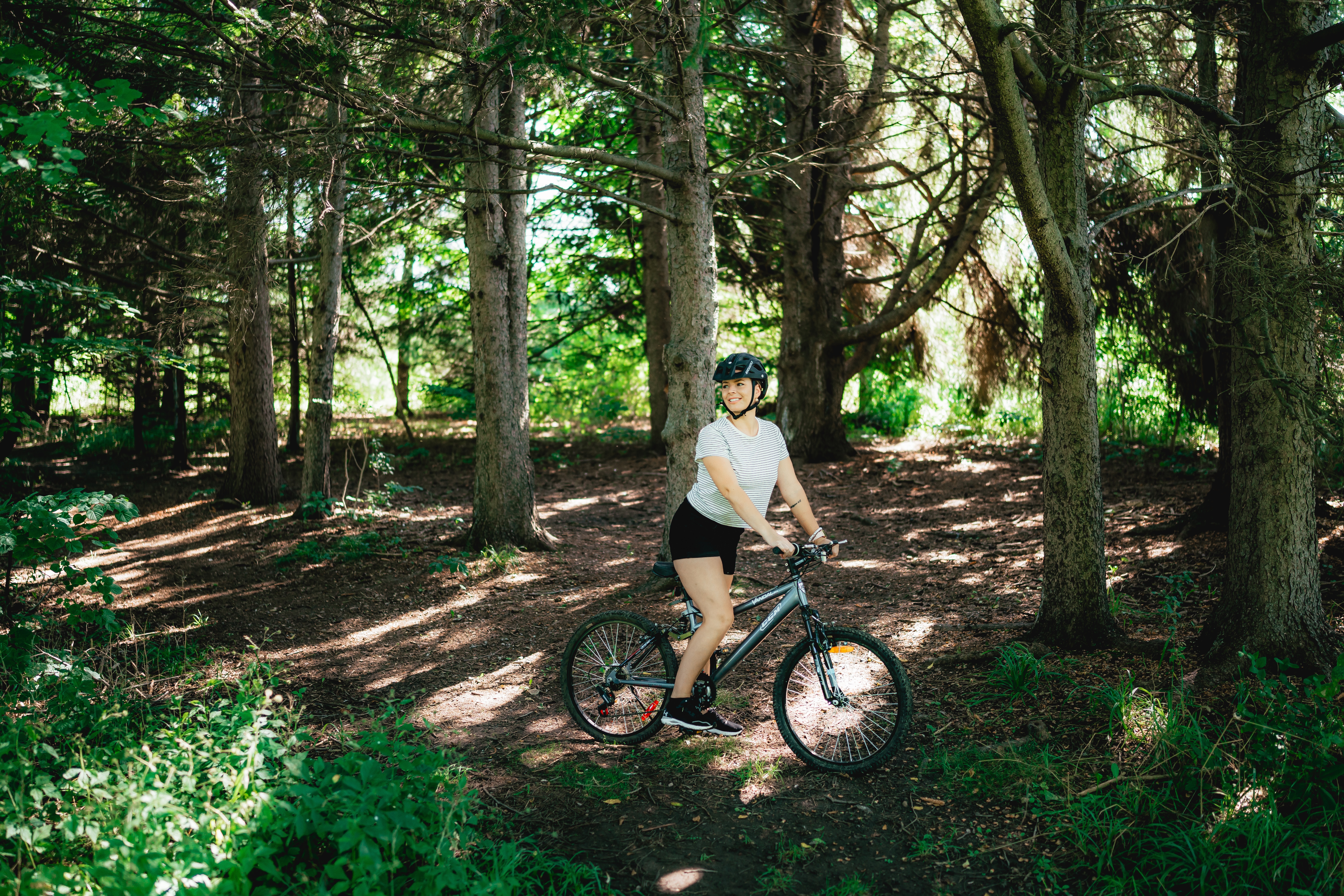A woman cycles through a forest