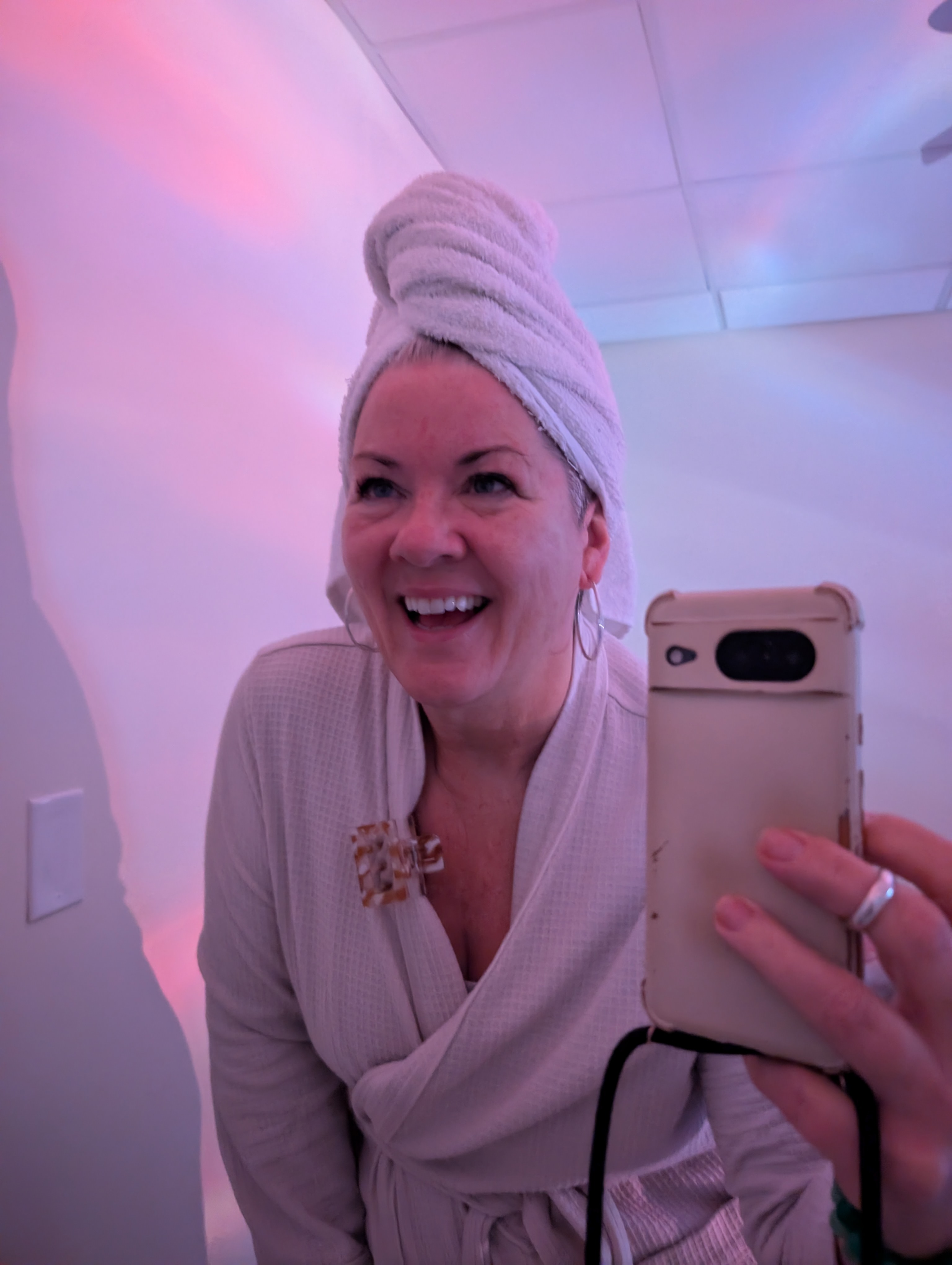 A woman in a robe and with a towel on her head prepares for a spa treatment