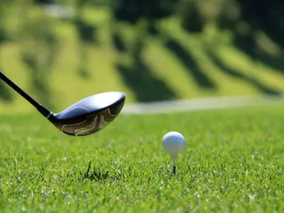 golf club about to hit a ball on a golf tee