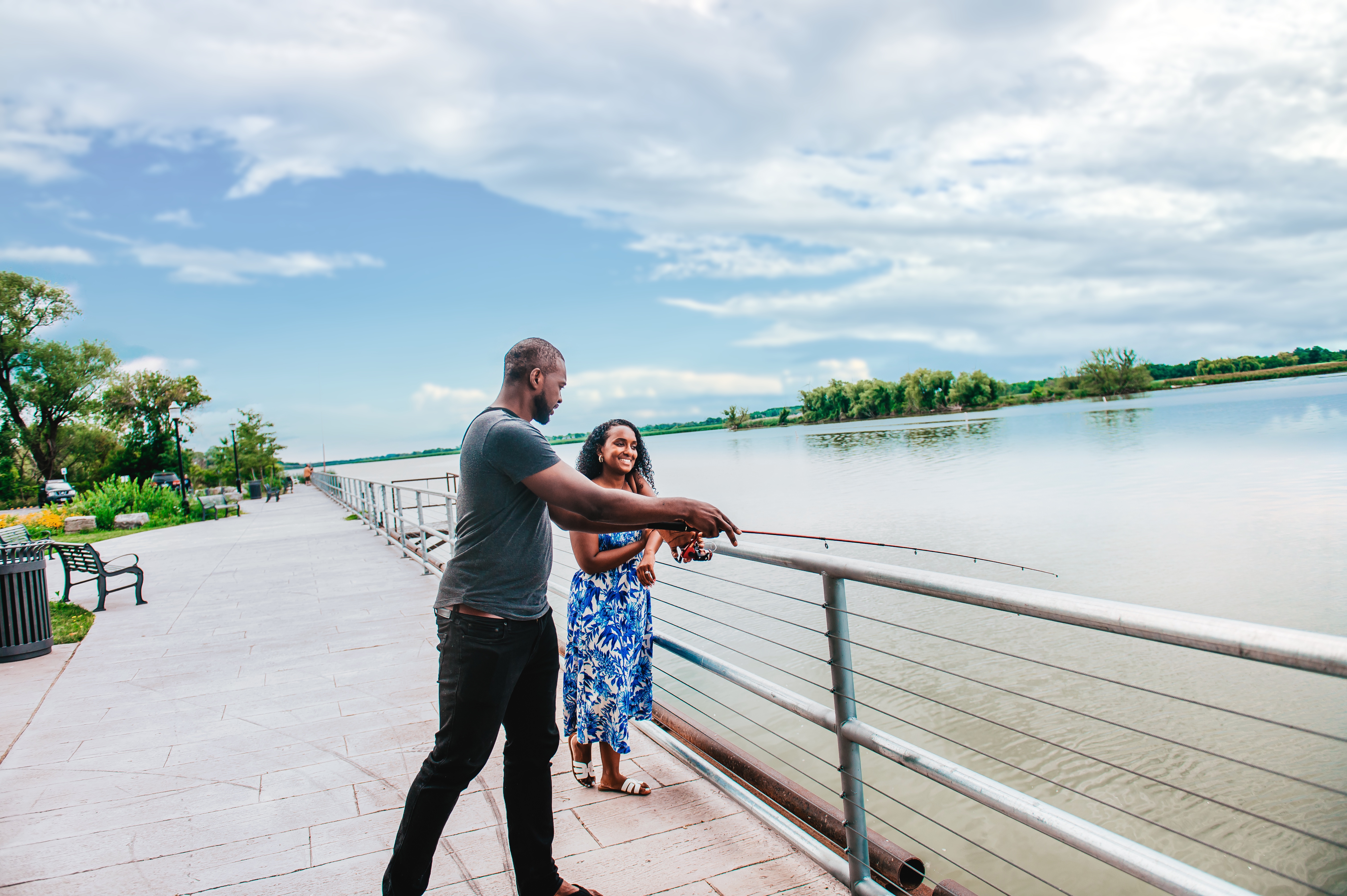 a man and woman fishing off of a platform
