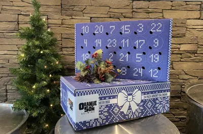 An beer advent calendar sit in front of a Christmas tree