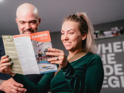 man and woman reading orange route guide