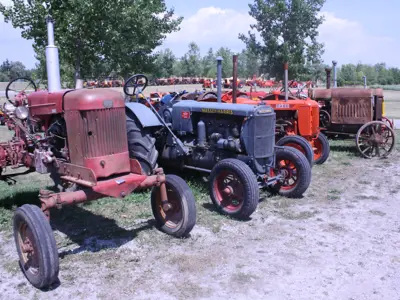 Antique tractors sit on display in a field