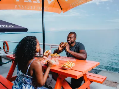 Couple eating lunch on patio by beach