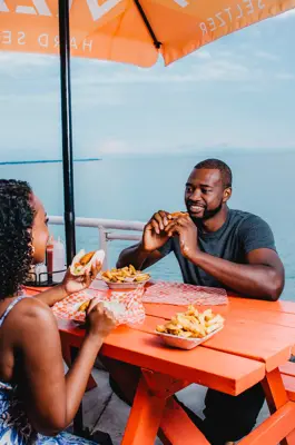 Couple eating lunch on patio by beach