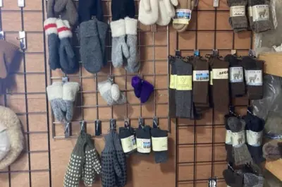 A wall rack covered in alpaca socks and mittens