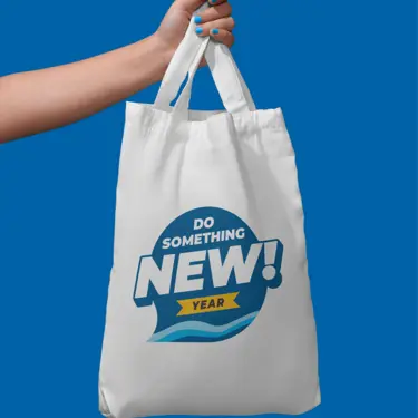 a hand holding a white cloth bag with Do Something New Year logo on it
