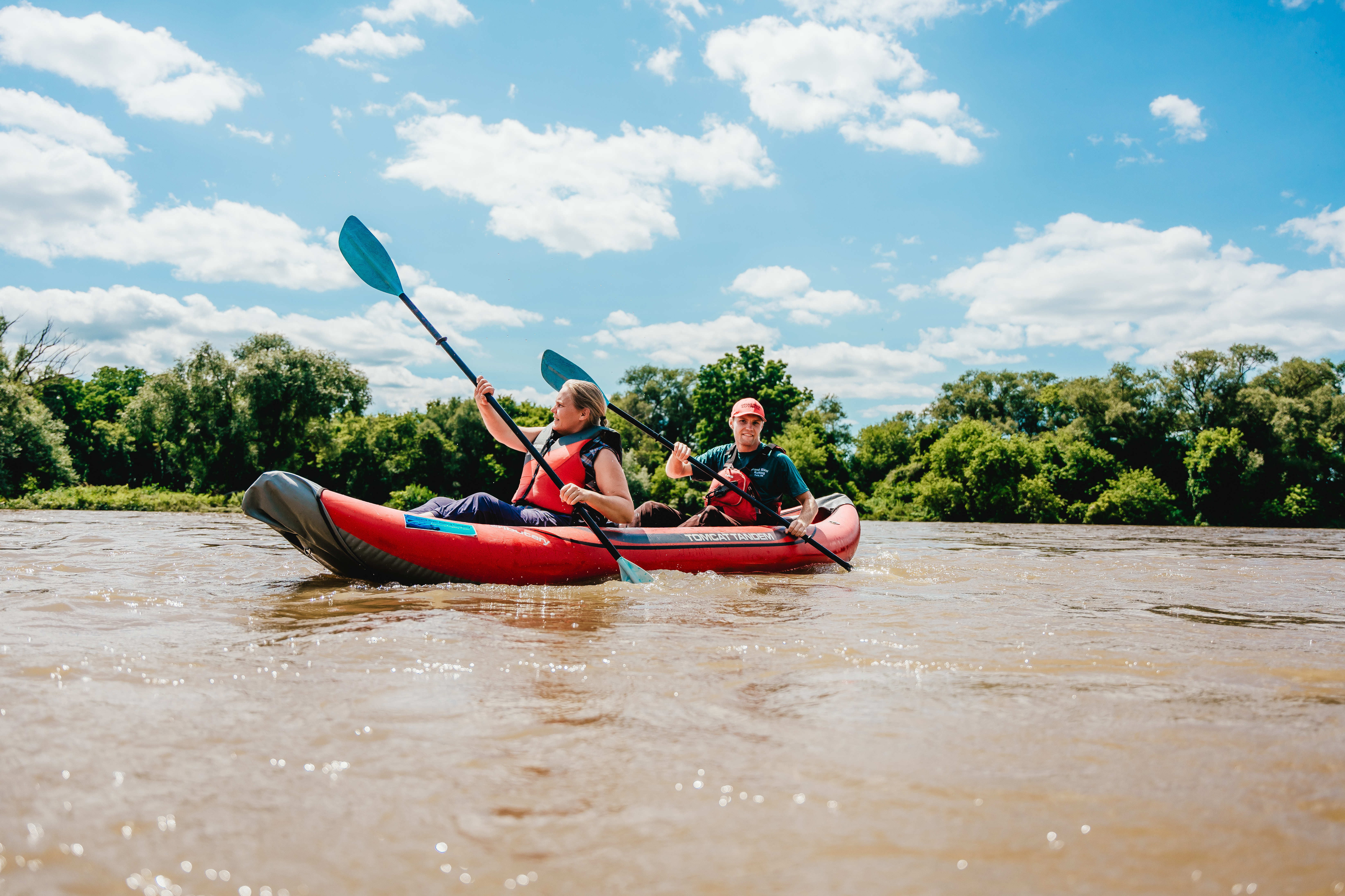 Two kayakers paddle a tandem inflatable boat