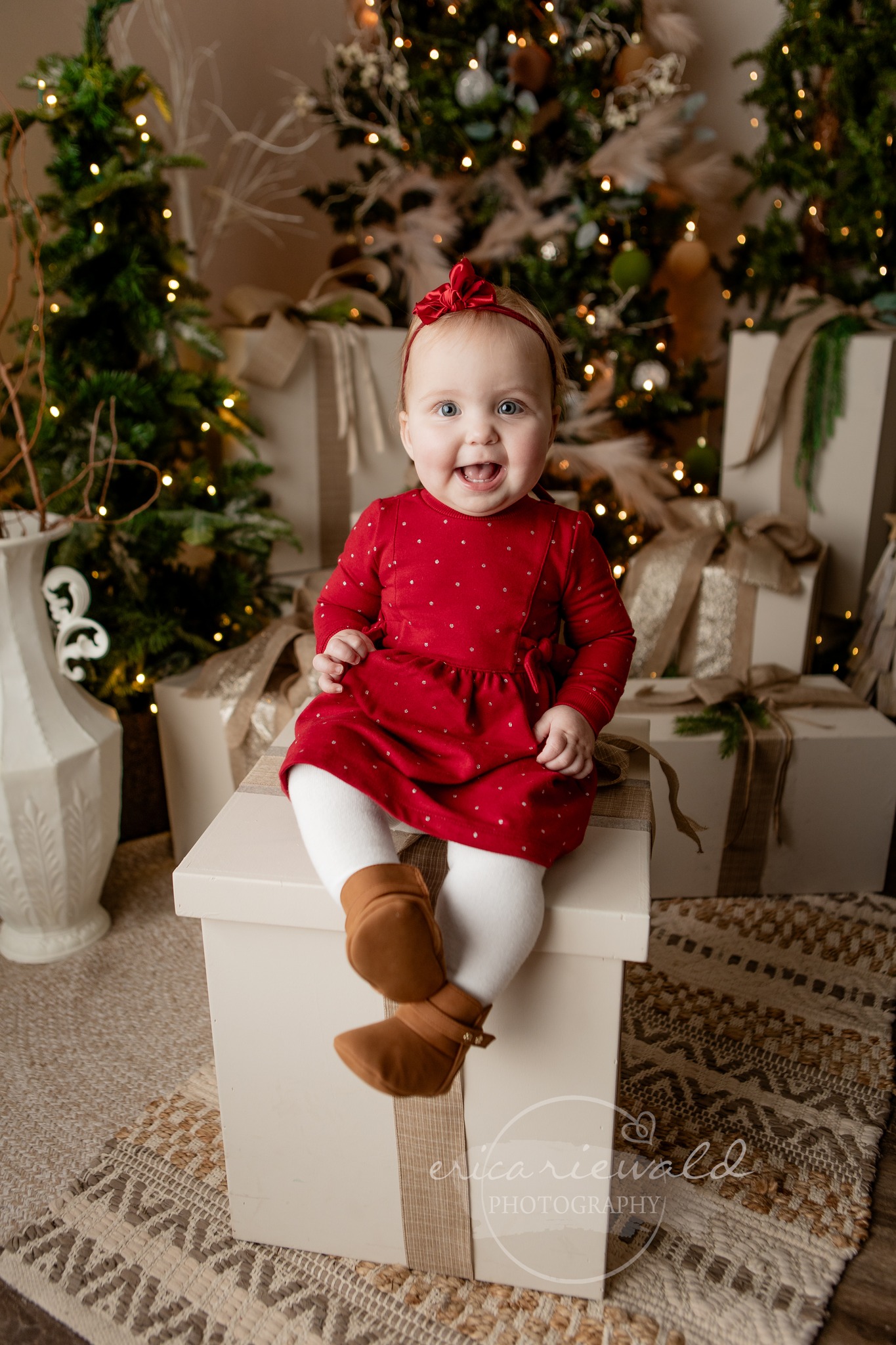 A baby poses for a Christmas photo decked out in a red dress