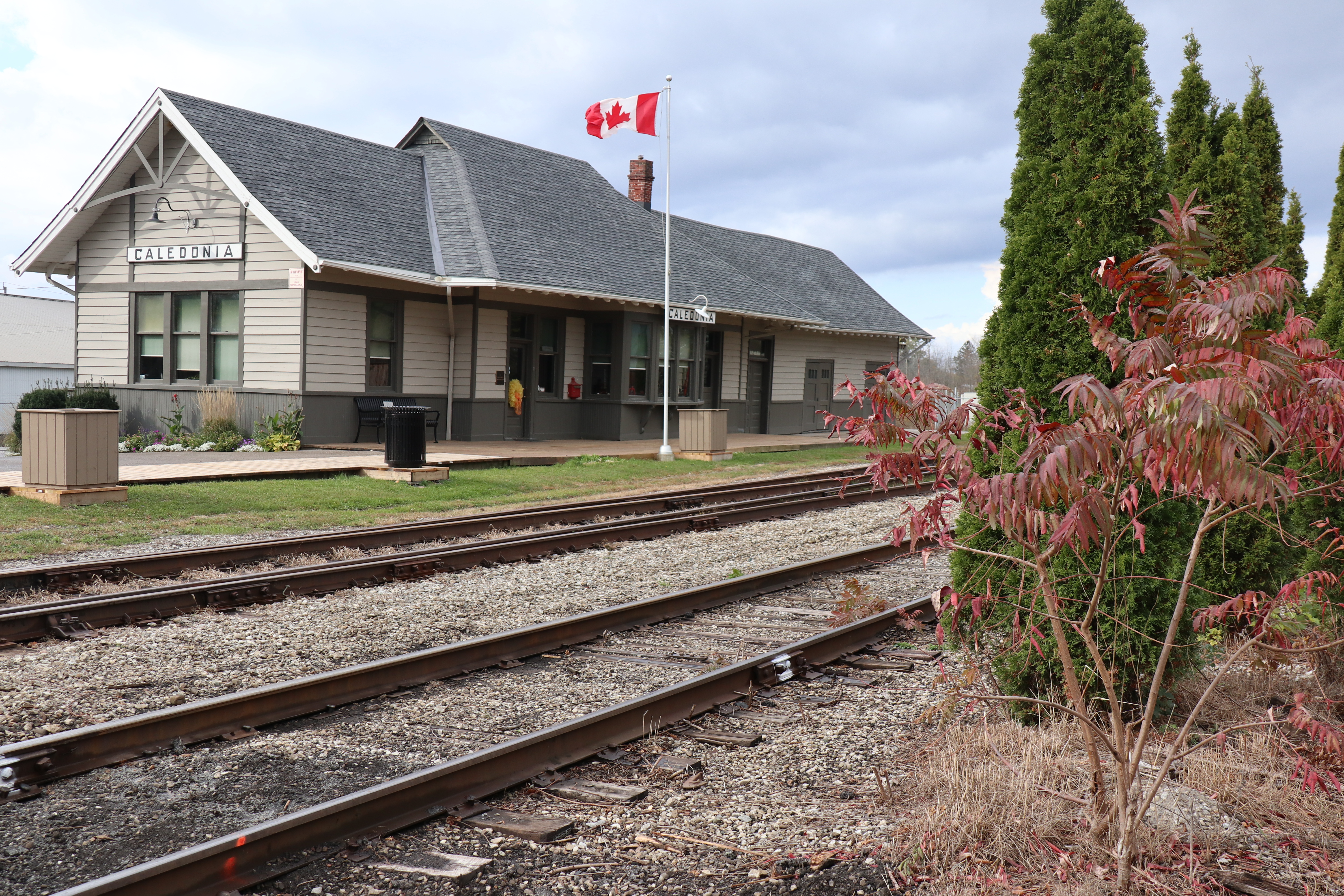 A railway station that now operates as a museum with Canadian flag