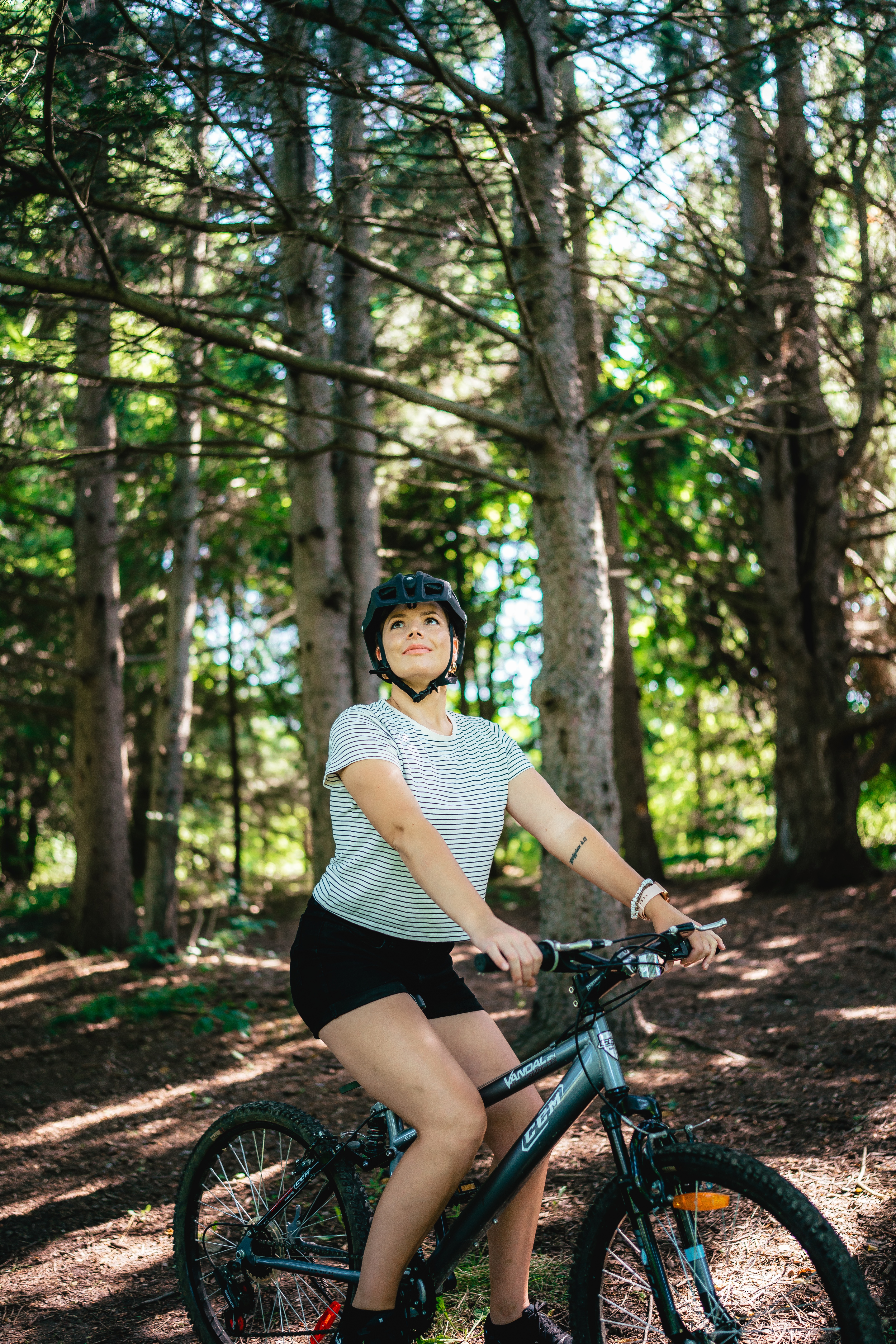 A woman bikes through a forest
