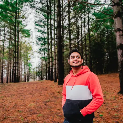 man looking up surrounded by trees