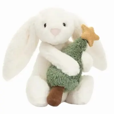 A stuffed white bunny holds a stuffed Christmas Tree with a gold star on top