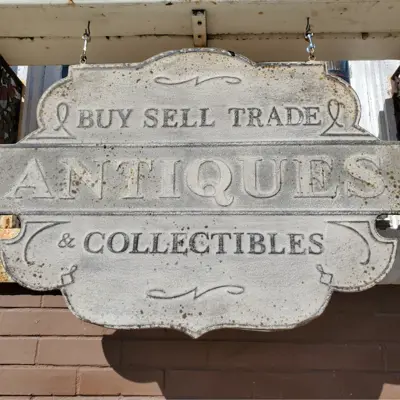 Outdoor sign that says "Buy sell trade Antiques & Collectables"