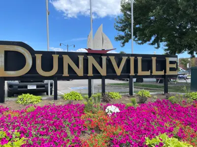image of Dunnville welcome sign with pink and yellow flowers below