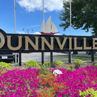 image of Dunnville welcome sign with pink and yellow flowers below