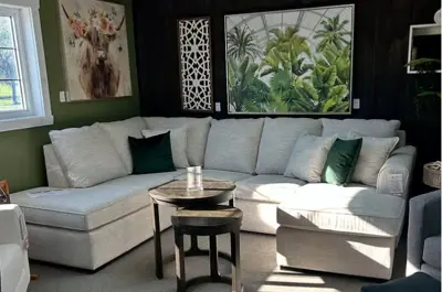 a cream sofa sits in a display room showcasing art and accessories