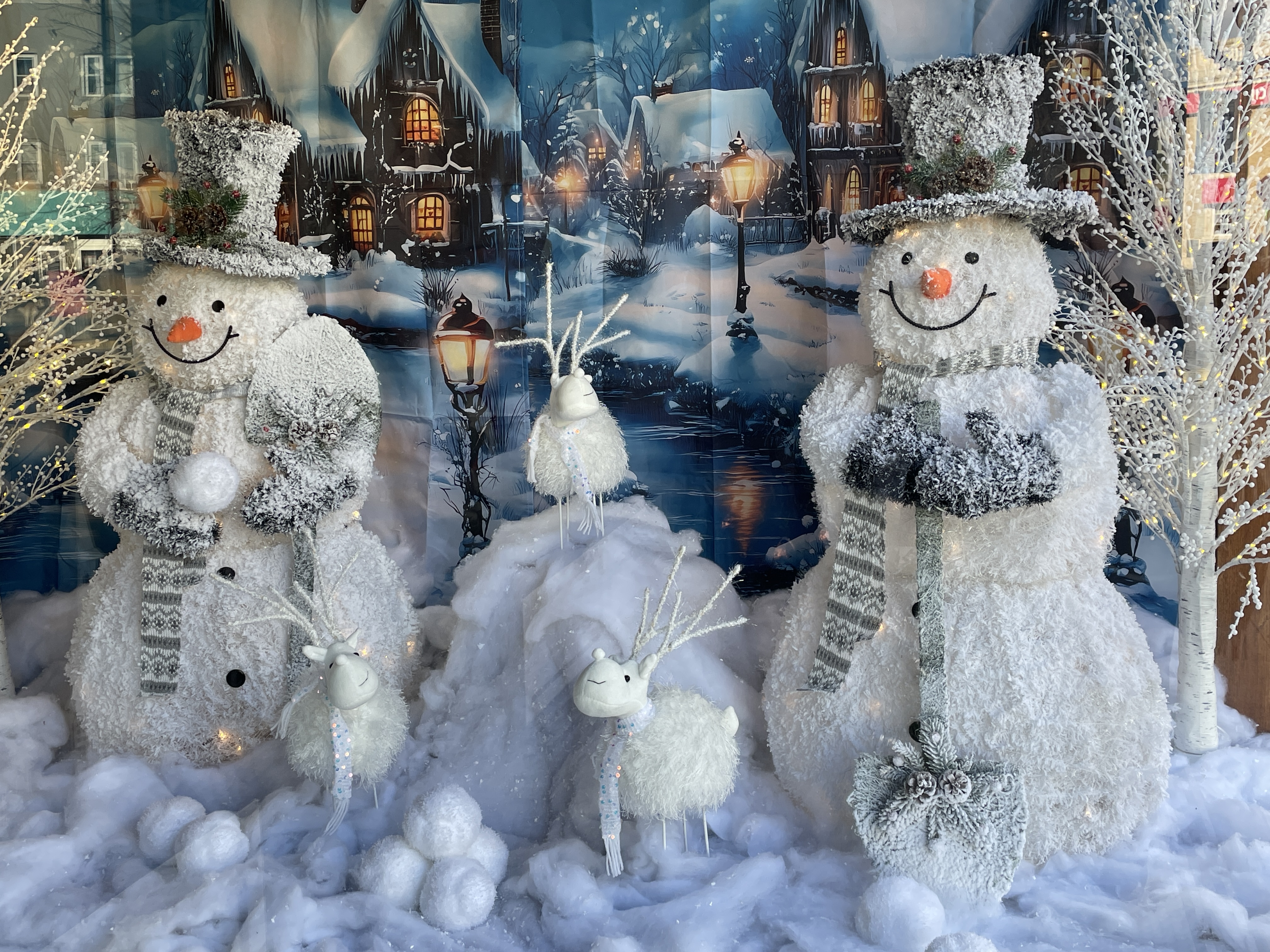 Snowmen decorations sit in a shop window