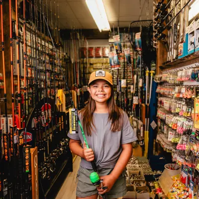 Kid holding a fishing rod in a store